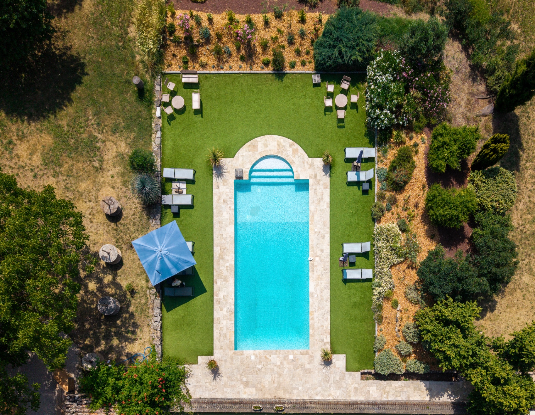 Vue aérienne d'une piscine entourée d'un jardin paysager