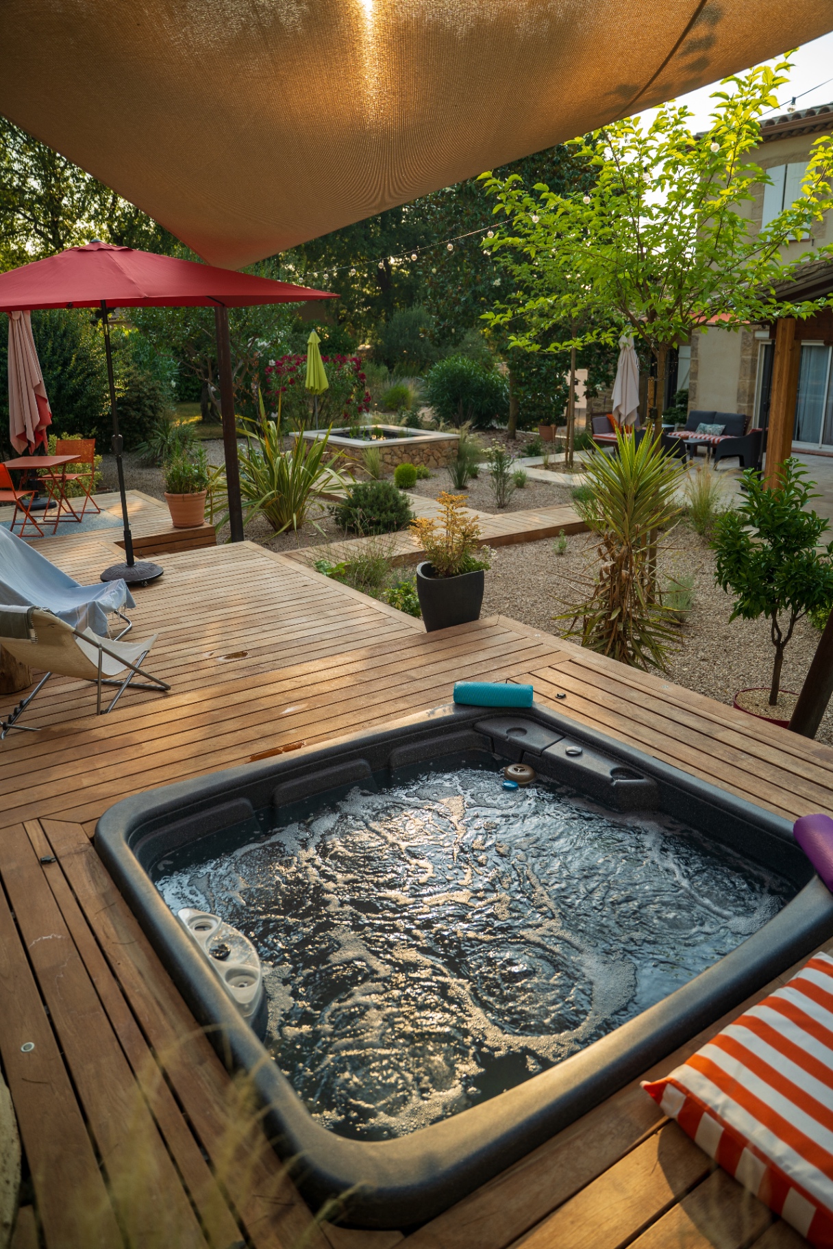 Spa en bois sous voile d'ombrage dans un jardin méditerranéen