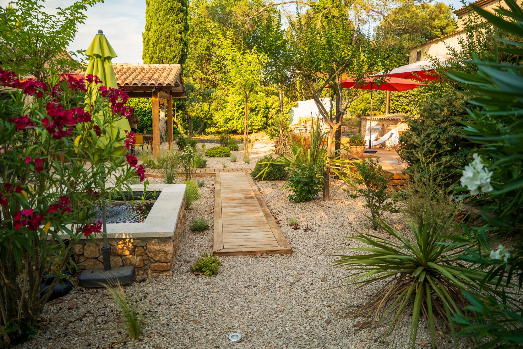 Jardin sec en gravier avec bassin en pierre et pergola