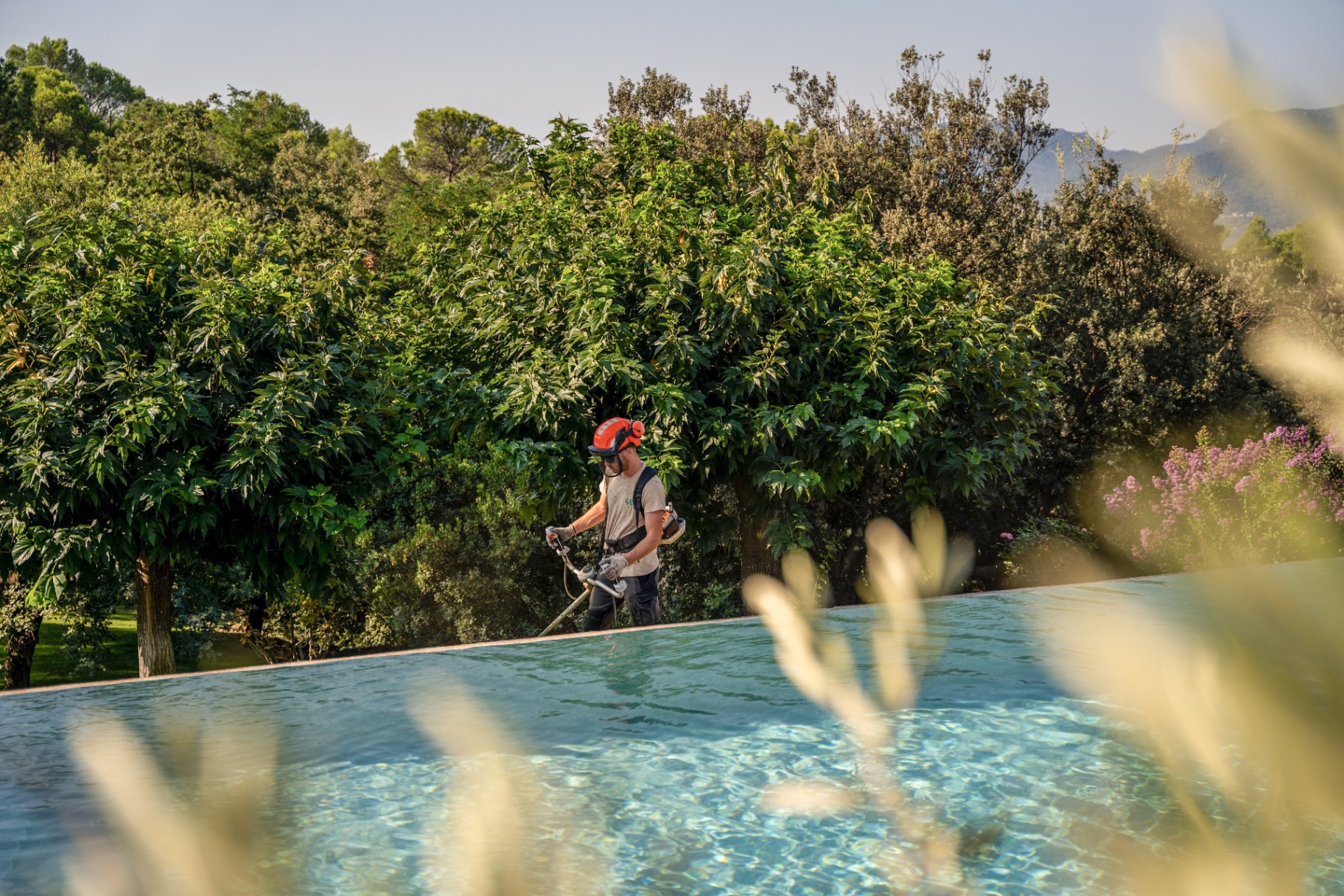 Débroussaillage au bord d'une piscine à débordement
